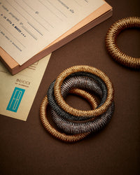 Stack of K.I.S.S. bracelets in 18k Yellow, Pink, White and Black Gold by Carolina Bucci.