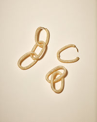 18k yellow florentine frosted finish gold 1885 grande links earrings on cream background