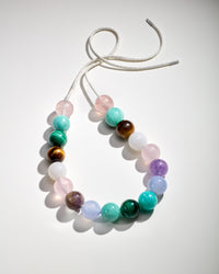 Nolita downtown necklace including Amethyst, Chalcedony, Amazonite, Malachite, Tiger's eye, Rose quartz and White agate semi precious spheres on white background