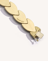 Close-up, back view of EveryDay bracelet clasp, brushed 18k yellow gold, engraved wish meanings, on white background