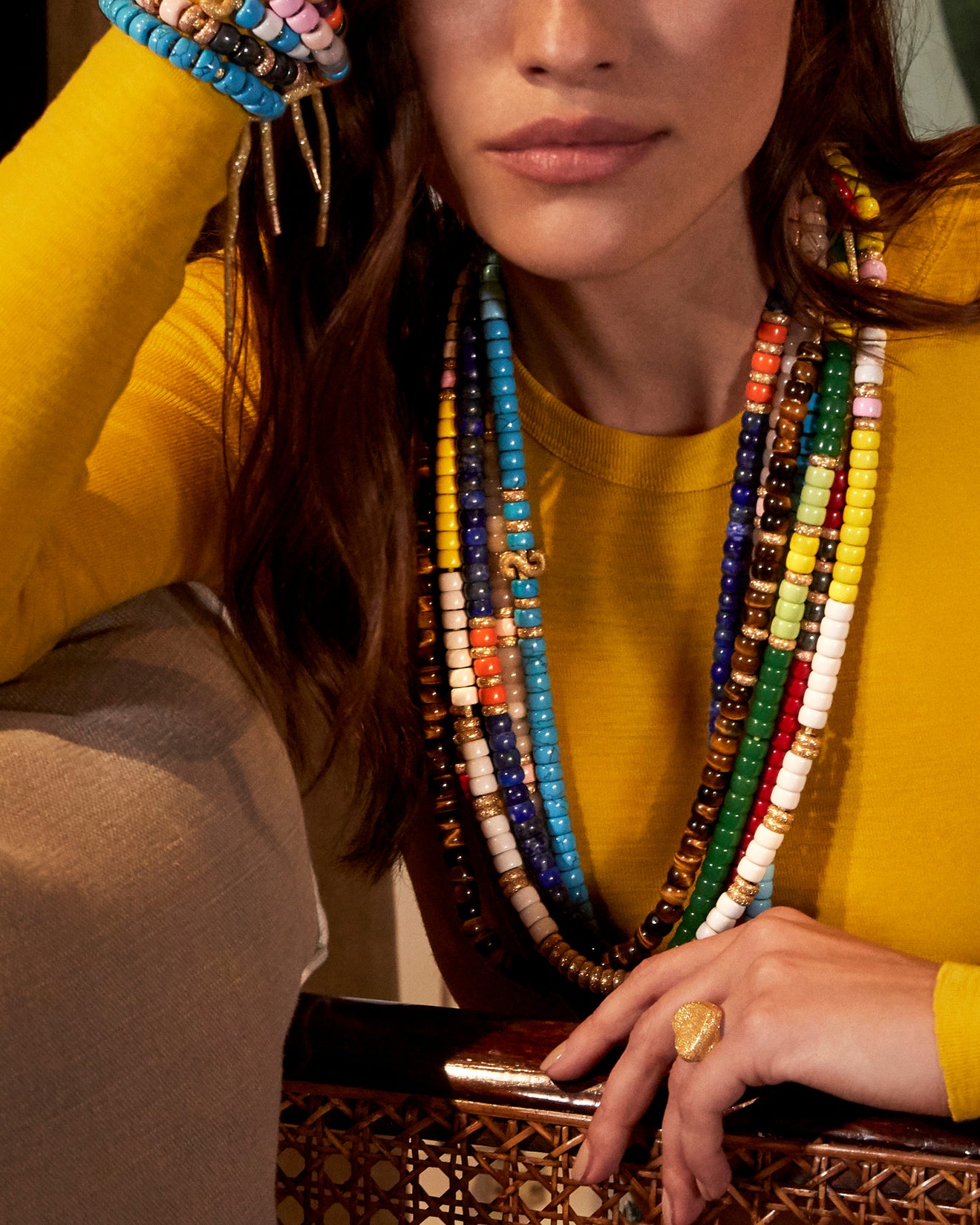 Model wearing a stack of colourful Carolina Bucci FORTE Beads necklaces.