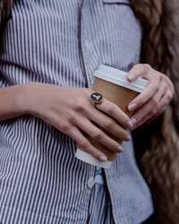 18K Yellow gold initial ring, with table of Labradorite stone and initial with white diamond pavé stones styled on model's index finger