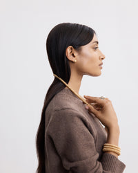 side profile of 18k yellow gold kiss necklace modelled with 18k yellow gold kiss necklace