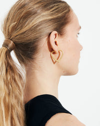 18k yellow florentine frosted finish gold small cuore hoop earrings close up modelled from behind
