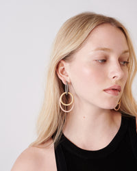 18k black florentine frosted finish gold small oval hoops with 18k white and yellow gold large oval and small round links close up on model 