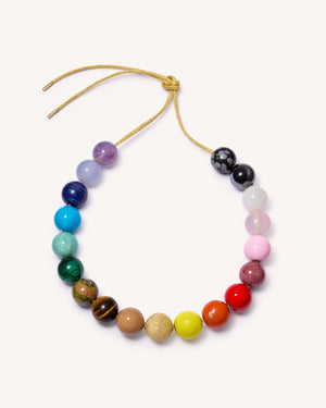 Soho gold necklace including amethyst, chalcedony, lapis lazuli, amazonite, malachite, unakite, tiger's eye, rhodonite, rose quartz, white agate, snowflake obsidian and hematite semi precious stones, sky, camel, lemon, terracotta, big apple red and flamingo coloured enamel spheres with an 18k yellow gold florentine frosted finish sphere