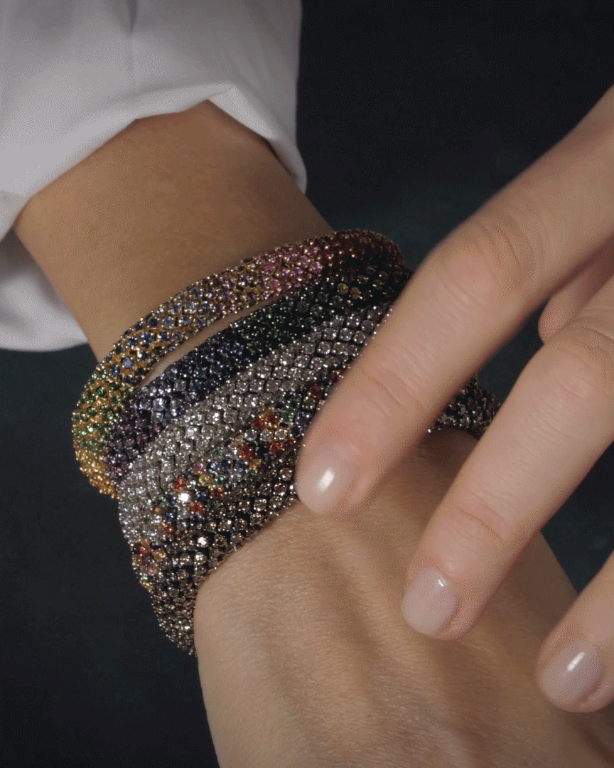 Carolina Bucci wearing 5 Twister Luxe bracelets made with multicoloured precious stones.