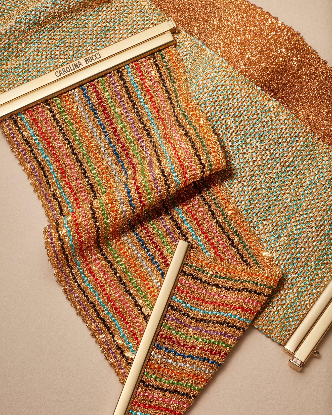 18k yellow gold 6cm rainbow striped woven bracelet presented with turquoise silk melange yellow, and pink all gold woven bracelet