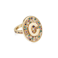 18K Yellow gold scarab initial ring, with table of multicolour pavé stones on white background