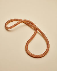 18k rose gold kiss necklace on white background