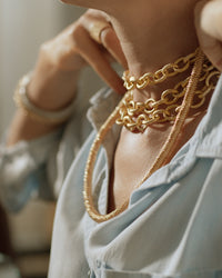 side profile of 18k yellow gold kiss necklace modelled with 18k florentine frosted finish yellow gold 1885 links necklace