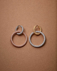 18k white and yellow florentine frosted finish gold round huggies, with 18k white and rose florentine frosted finish small round links on saddle brown background