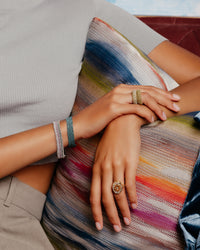 melange 1 cm woven bracelets modelled with woven rings and 18k rose gold initial ring