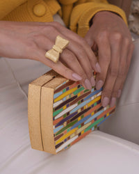 18k yellow florentine frosted finish gold woven rainbow clutch bag with multicoloured enamel modelled with 18k yellow florentine frosted fish gold tutto per te ring