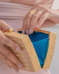 close up of 18k yellow florentine frosted finish gold woven wishes clutch bag with layered enamel with 18k florentine frosted finish cuff ring