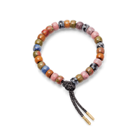 Kyoto forte beads bracelet with storm lurex tie cord with 18k yellow gold caps on white background