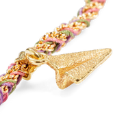 close up of 18k yellow gold lucky re-engage bracelet with paper plane charm on white background