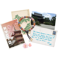 Kyoto forte beads bracelet with storm lurex tie cord with 18k yellow gold caps on white background with kyoto postcards